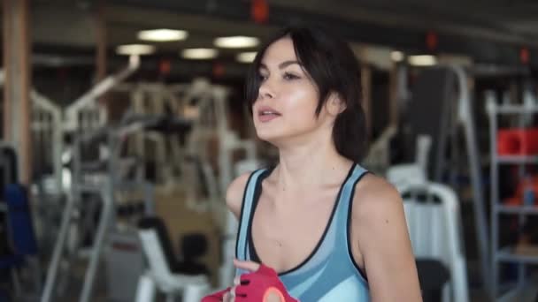 Menina correndo na esteira na sala de fitness. mulher jovem fazendo exercícios aeróbicos. Exercício no ginásio, treino de cardio esteira. Movimento lento — Vídeo de Stock