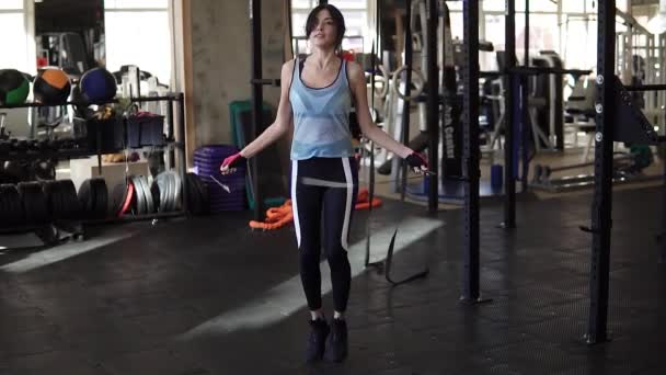 Saltare l'allenamento femminile in palestra. In forma giovane donna saltando corda — Video Stock