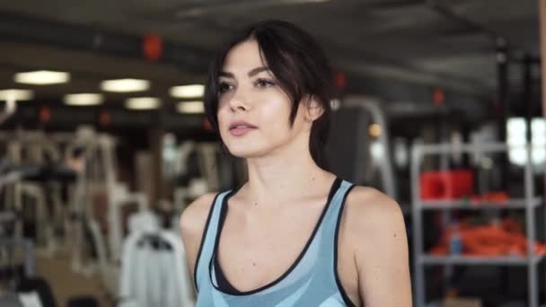 Портрет крупным планом девушки на беговой дорожке в спортзале — стоковое видео
