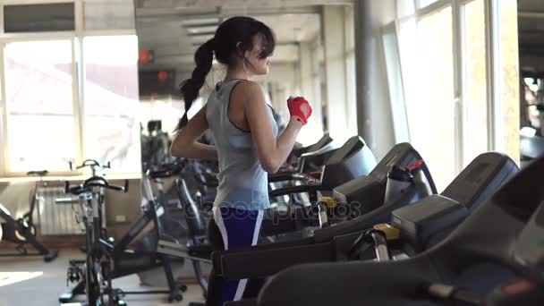 Krásné fit mladá žena ve sportu v tělocvičně. dívka na běžeckém pásu — Stock video
