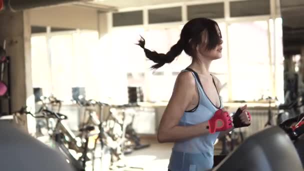 Primo piano ritratto di una ragazza sul tapis roulant in palestra — Video Stock