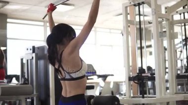 çekici sporcumuz bir eğitim aparatı spor salonunda bir egzersiz yapıyor. arka kasları üzerinde bir egzersiz yaparak kız