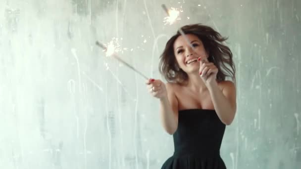 Girl with the sparklers in the hands of carefree dancing and having fun. a festive mood. young woman enjoying a party. slow motion — Stock Video