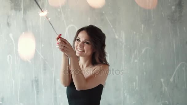 Wesoła dziewczyna, trzymając w rękach zimne ognie i śmiejąc się. Młoda kobieta na imprezie. świąteczny nastrój. zwolnionym tempie — Wideo stockowe