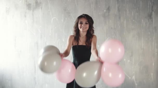 Jovem alegre joga balões e sorrindo. o clima festivo. sentido de celebração. câmara lenta — Vídeo de Stock