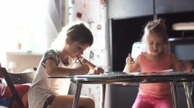 iki küçük kız mutfak masada oturan boya kalemi ile çizmek