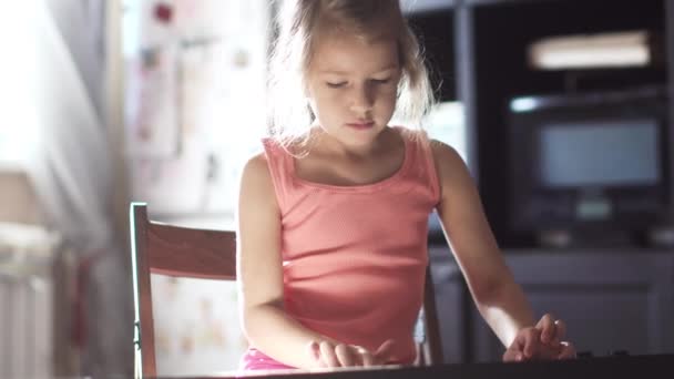 Menina 6 anos aprendendo a tocar piano. a criança ensaiar uma peça de música — Vídeo de Stock