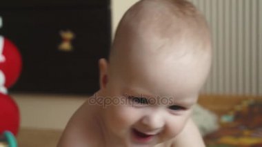 küçük bebeğim 1 yaşında yakın çekim. Çocuk evin zemininde yatıyor. kamera ve gülümsüyor küçük çocuk gibi