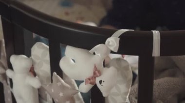 genç anne küçük oğlu bir şişe süt ile beslenir. Çocuk beşiğinde uyuyor. anne çocuk için umurunda değil.