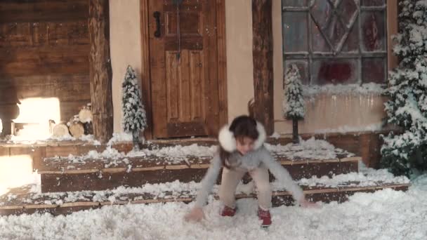 Navidad o Año Nuevo. niño tontos alrededor y se encuentra en la nieve artificial. retrato de un niño en decoraciones navideñas. cámara lenta — Vídeos de Stock