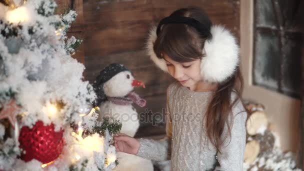 Karácsony vagy újév. egy kis lány lóg a karácsonyfa díszek. nyaralás érzésével — Stock videók
