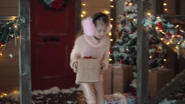 Noël ou Nouvel An. une petite fille offre à sa petite amie un beau cadeau pour Noël. enfants dans le contexte de la décoration du Nouvel An — Video