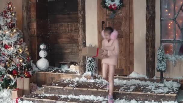 Navidad o Año Nuevo. los niños se regalan unos a otros para Navidad en el árbol de Año Nuevo. pequeña niña está llevando un regalo a su novia — Vídeos de Stock