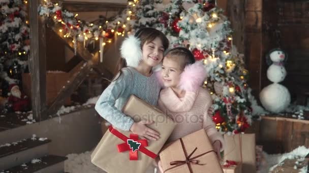 Noel ve yeni yıl. güzel paketlenmiş hediyeler tutan iki küçük kız portresi. alınan çocuk hediyeleri Noel için — Stok video