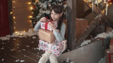 Noel ve yeni yıl. küçük kız holding sinsice gülümser ve hediyeler ile bir kutu eller. birçok armağan üstünde Noel alınan çocuk