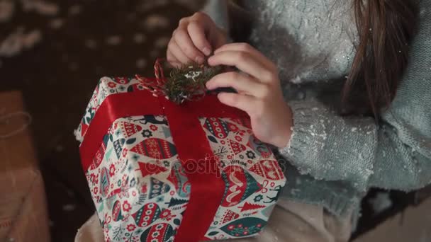 Jul eller nyår. en liten flicka ser en ruta av gåvor — Stockvideo