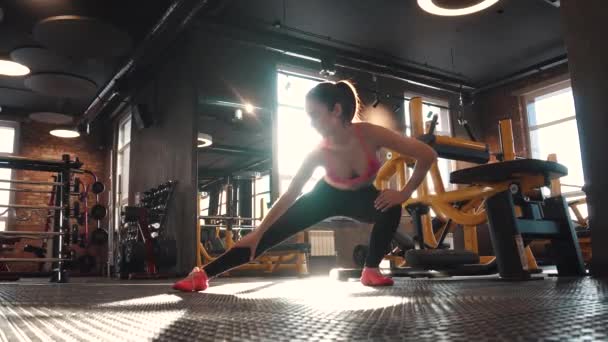 Фитнес-девушка делает разминку в спортзале. растяжение и подготовка к тренировкам — стоковое видео