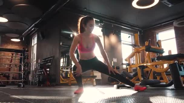 Fitness meisje warming-up in de sportschool doen. rekken en voorbereiding op training — Stockvideo