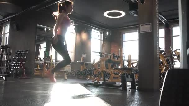 女性のワークアウトのジムでトレーニングをスキップしています。縄跳びフィットの若い女性 — ストック動画