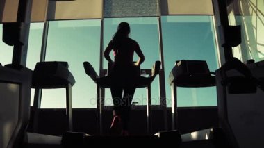 kardiyo koşu bandı üzerinde. kilo kaybı için egzersizler. bir kız bir koşu bandı üzerinde silüeti. spor salonunda treadmill çalışan genç sportif kız. Spor atlet