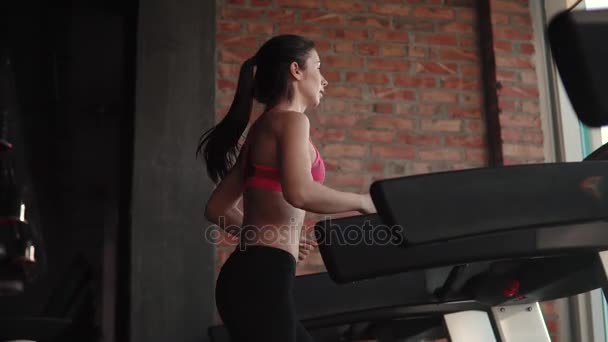 Портрет крупным планом девушки на беговой дорожке в спортзале. Кардио на беговой дорожке. упражнения для похудения . — стоковое видео