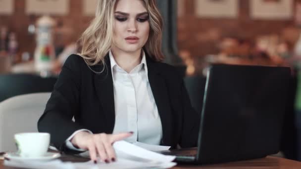 Mulher de negócios trabalhando com documentos sentados em um aconchegante café — Vídeo de Stock