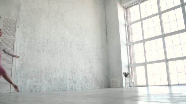 Joven bailarina saltando alto. Chica graciosa practicando ballet en el estudio. hermosa bailarina de ballet realiza un salto, y ballet clásico — Vídeos de Stock