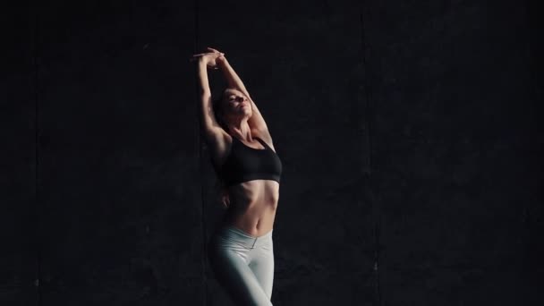 Ung vacker flicka gymnast uppvärmning innan ett träningspass. flicka i sportkläder — Stockvideo