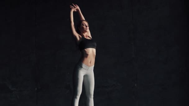 Menina praticando ioga. o atleta faz um alongamento antes do treinamento. jovem mulher em roupas esportivas — Vídeo de Stock