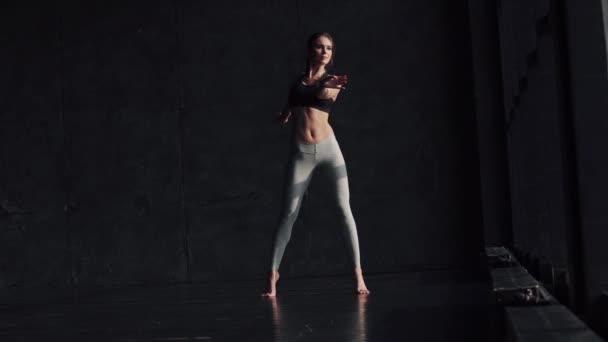 Ragazza flessibile si sta riscaldando. giovane donna in abbigliamento sportivo facendo yoga — Video Stock