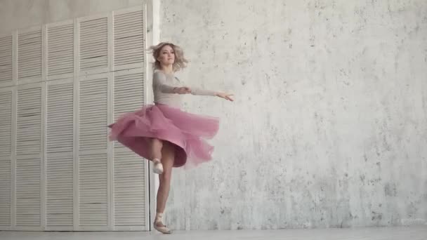 Die Ballerina dreht sich in einem rosafarbenen Kleid um ihren Zeh. junges Mädchen tanzt klassisches Ballett.