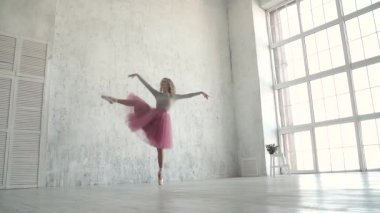 kız dans etmek büyük bir pencere arka planı. Balerin studio pirouettes gerçekleştirmek. balet klasik tutu ve pointe