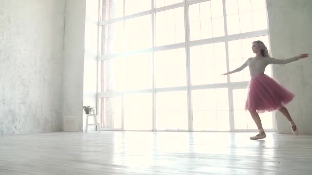 Балетна танцівниця крутиться і стрибає високо в туалеті для навчання та пізнання. молода балерина танцює. повільний рух — стокове відео