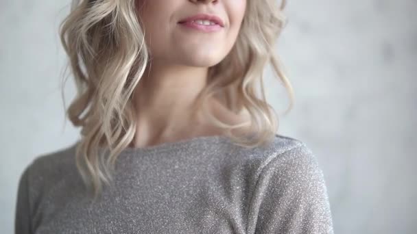 Close-up portret van een aantrekkelijke blonde. jong meisje met een lichte make-up en krullen — Stockvideo
