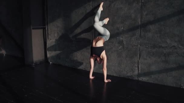 Menina fazendo ioga. ginasta de pé em suas mãos — Vídeo de Stock
