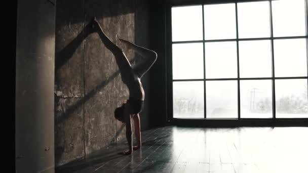 Chica haciendo yoga. gimnasta de pie sobre sus manos — Vídeos de Stock