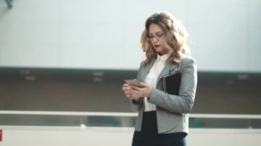 genç kadın takım elbise tipik haber üstünde hareket eden telefon. bir ofis binası içinde bir iş kadın portresi