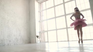 Bale dansçısı büyük bir ışık pencere arka planı dönüyor. bir klasik tutu ve pointe balerin. ağır çekim