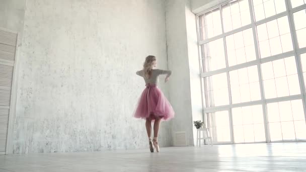 En ung balettdansös i en klassisk tutu och pointe skor danser och virvlar på tå. slowmotion — Stockvideo