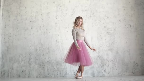 Uma jovem bailarina em um pacote clássico rosa e sapatos pontiagudos dança graciosamente. beleza e graça do balé — Vídeo de Stock