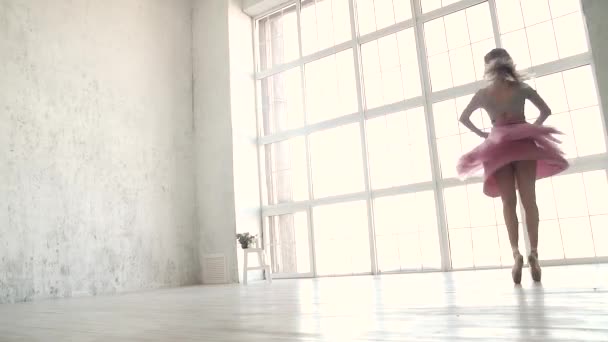 Bailarino ballet girando dinamicamente contra o fundo de uma grande janela brilhante. bailarina em um tutu clássico e sapatos Pointe — Vídeo de Stock