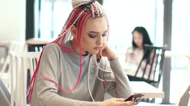 Retrato de una chica con rastas en un café. un adolescente con una apariencia inusual. subcultura de la juventud moderna — Vídeos de Stock