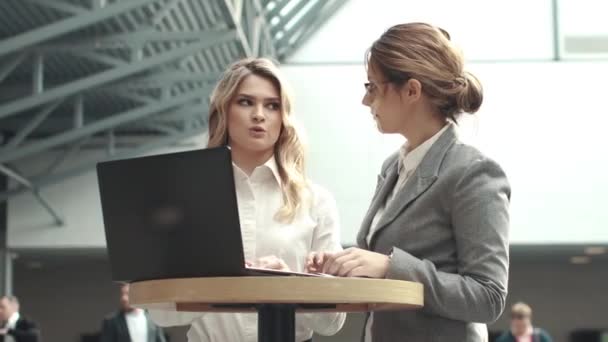 Reunión de negocios de dos mujeres seguras. chica escribiendo texto en el ordenador portátil — Vídeo de stock