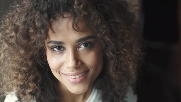 Kopfschuss-Porträt eines attraktiven hispanischen Mädchens mit einem schönen Lächeln. Mulattin lächelt und blickt in die Kamera — Stockvideo