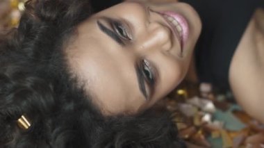 konfeti ve glitter ile büyüleyici bir genç İspanyol kadın yakın çekim portresi. kavramı tatil, eğlence, kutlamak. ağır çekim