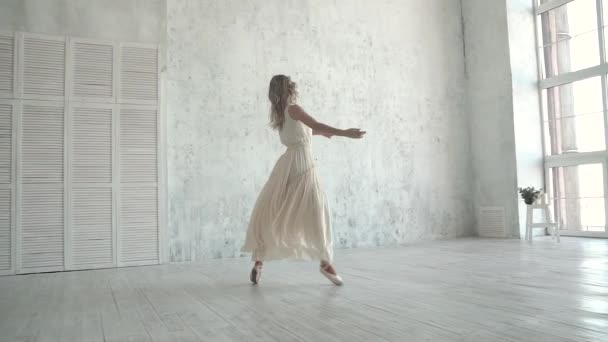 Hermosa bailarina joven bailando en una luz, vestido volador sobre un gran fondo de ventana — Vídeos de Stock