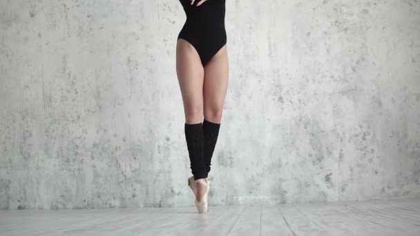 Ballerinas legs close-up. ballet dancer in black bodysuit and pointe dance on tiptoe. slow motion — Stock Video