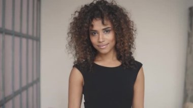 yakın çekim portre bir kıvırcık kız. güzel makyaj ve saç modeli. güzel bir gülümseme ile çekici bir İspanyol kız portresi headshot