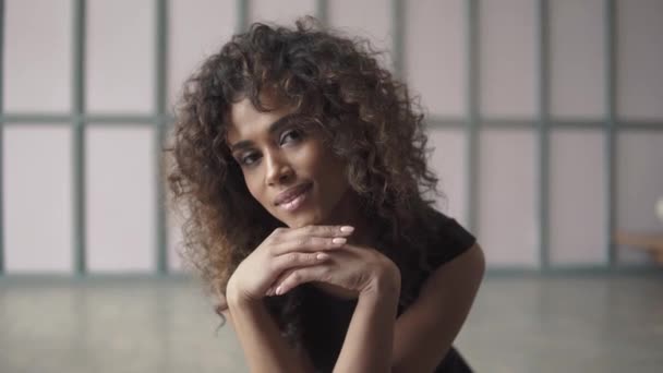 Close-up portrait of a cute young woman with curly hair and a charming smile — Stock Video