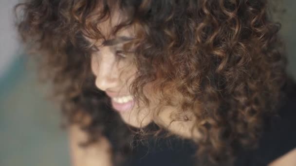 Curly flicka vänder och tittar på kameran. närbild porträtt — Stockvideo